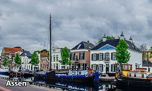 Canal with boats and historic houses in Assen, Drenthe, Netherlands.