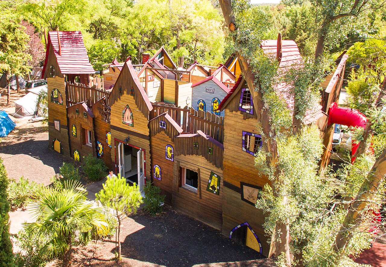 Large wooden play structure with slide at CAPFUN Fumades campsite in ALLEGRE-LES-FUMADES.