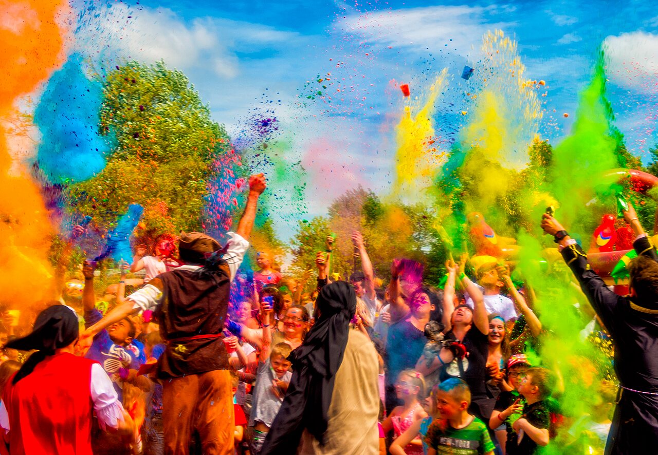 Vibrant color powder festival with guests enjoying the animation at CAPFUN Fumades campsite.