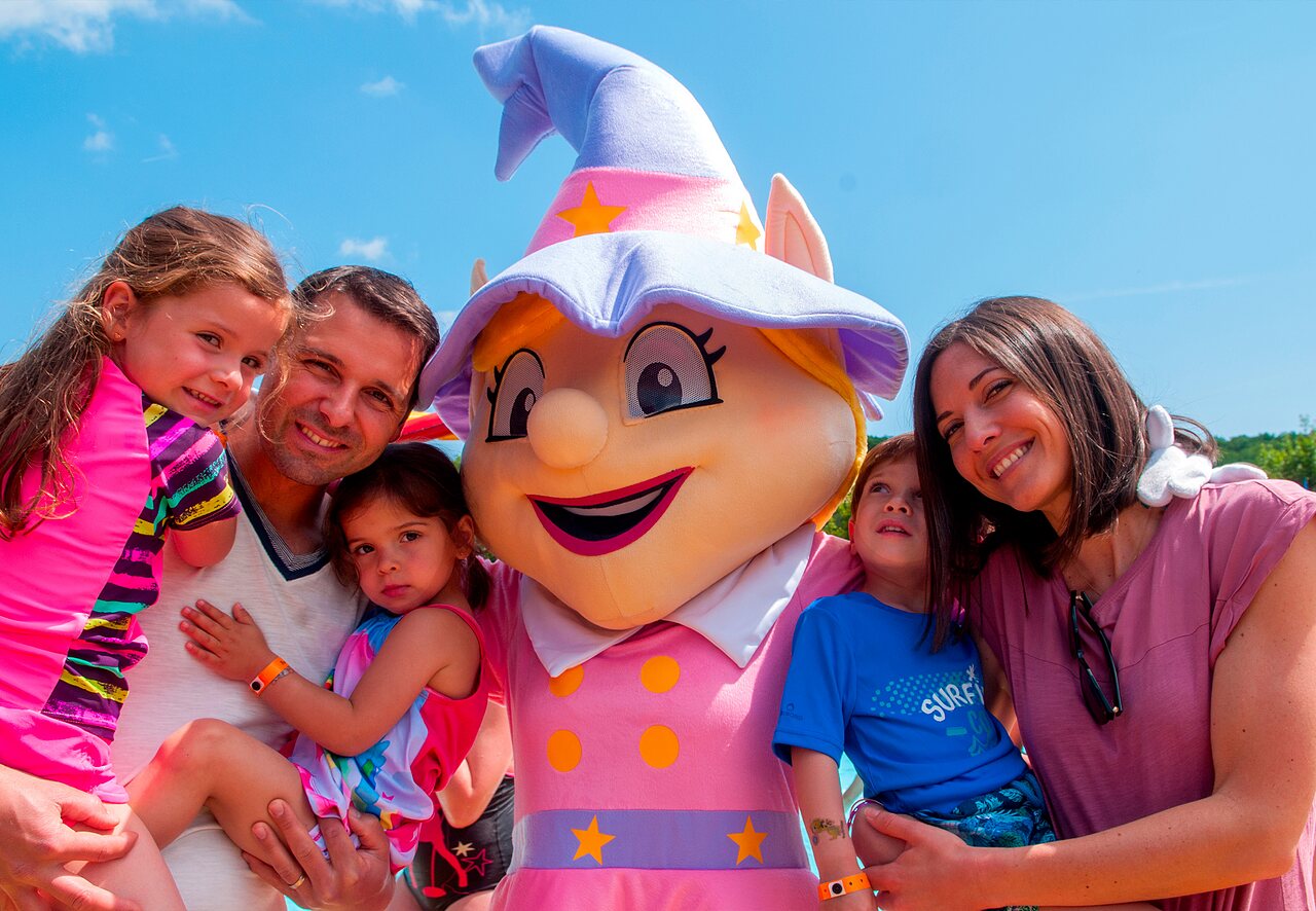 Smiling family with the mascot at CAPFUN Fumades campsite in ALLEGRE-LES-FUMADES (30).