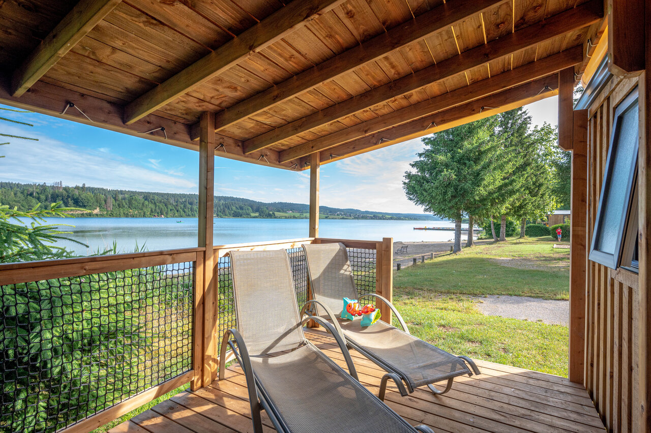 Accommodation terrace with sun loungers and lake view at CAPFUN Fuvettes campsite in Malbuisson (25).