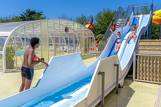 Water slides and covered swimming pool at CAPFUN Golf campsite in SAINT JEAN DE LA RIVIERE.