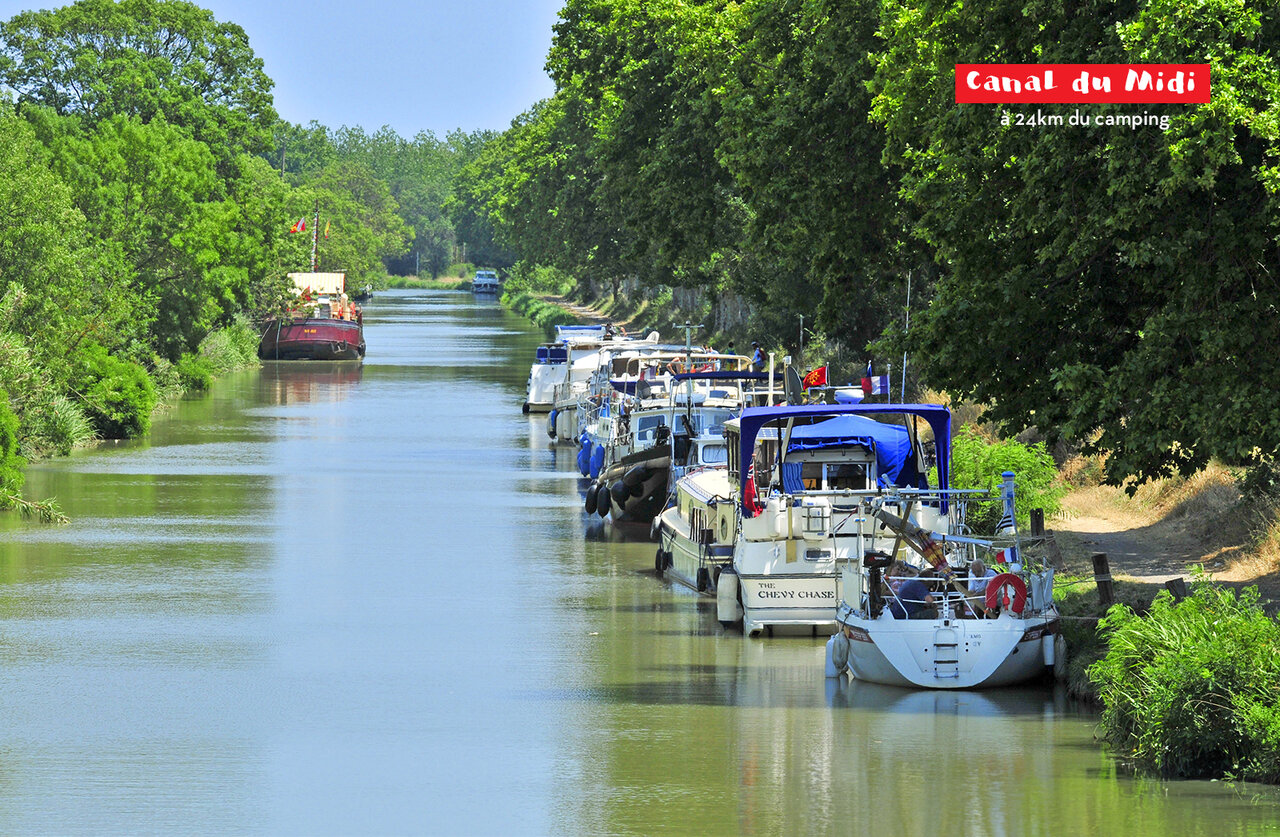 Canal du Midi, moored barges, lush nature, a place to visit near the campsite.