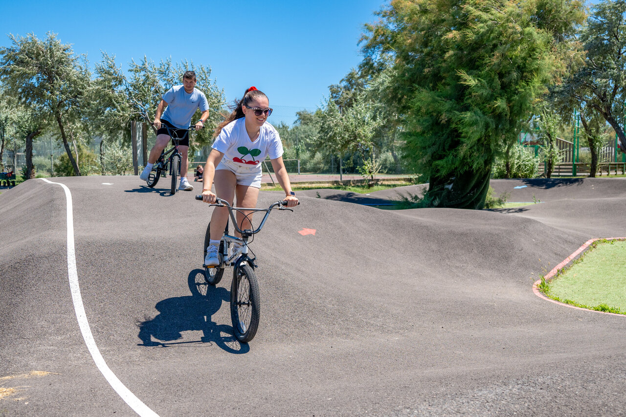 Pump track with two cyclists at CAPFUN Grande Cosse campsite.