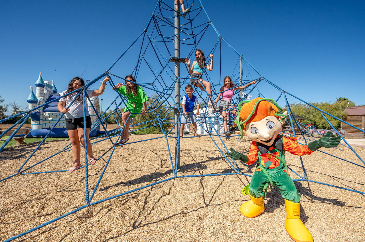 Children on climbing structure and mascot at CAPFUN Grande Cosse campsite in Saint Pierre la Mer.