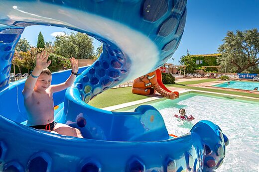 Child on blue water slide and pool at CAPFUN Grande Cosse campsite in Saint Pierre la Mer (11).