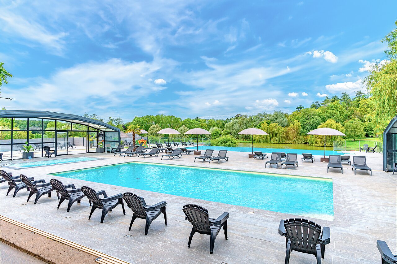 Outdoor swimming pool with sun loungers and lake in background at CAPFUN Grand Cerf campsite in Gimouille.