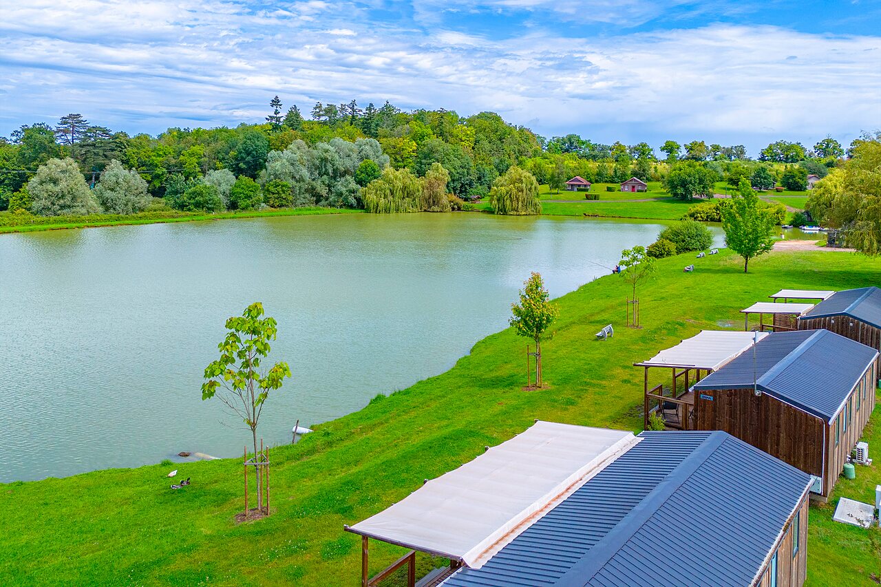 Peaceful lake, wooden accommodations and greenery at CAPFUN Grand Cerf campsite in Gimouille (58).