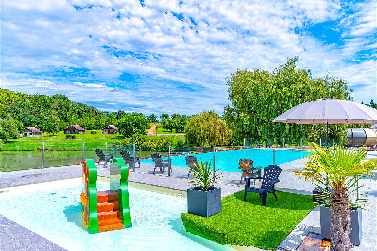 Outdoor swimming pool with children's slide and lounge chairs at CAPFUN Grand Cerf campsite in Gimouille (58).