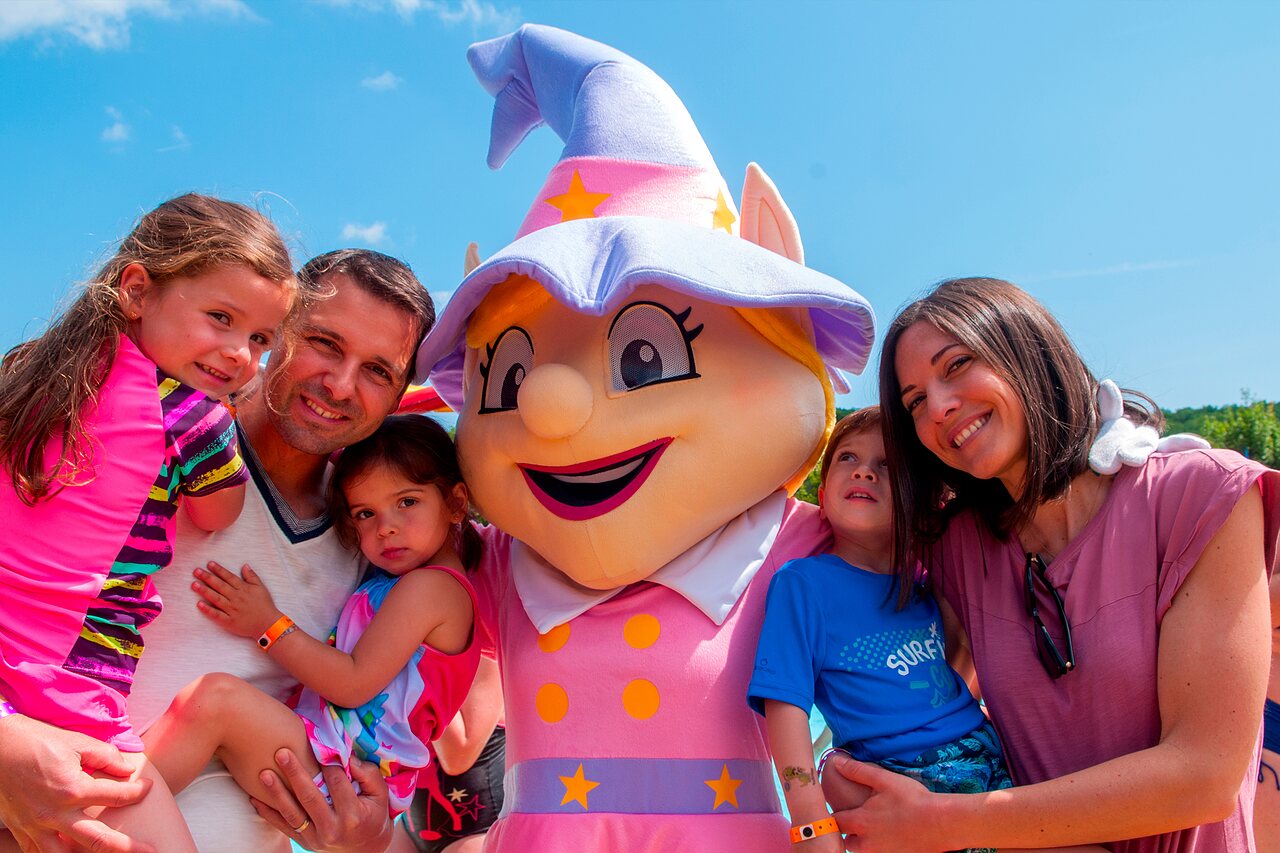 Campsite mascot with smiling family and children at CAPFUN Grand Cerf in Gimouille.
