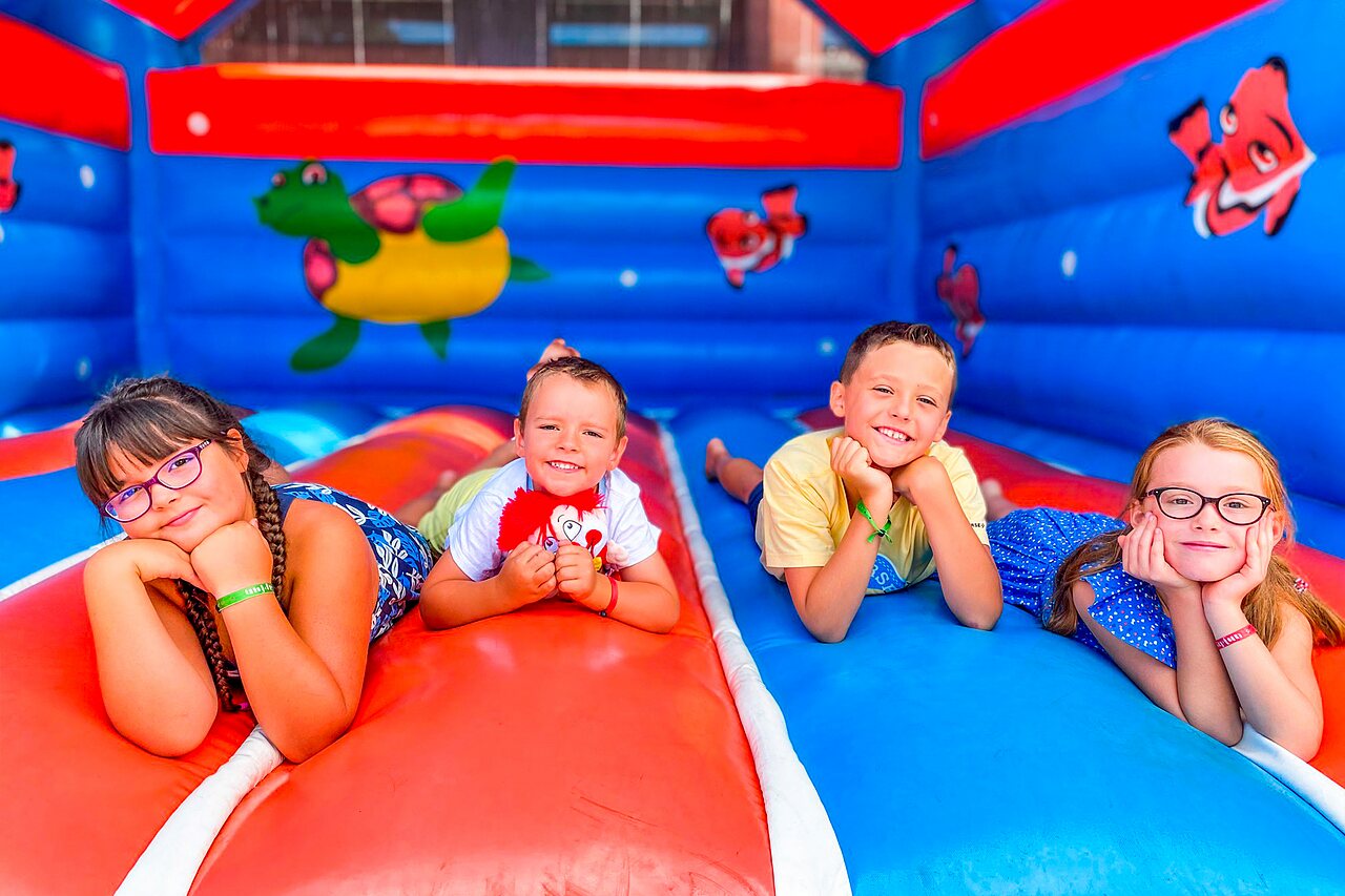Colorful inflatable structure with smiling children at CAPFUN Grand Cerf campsite in Gimouille (58).