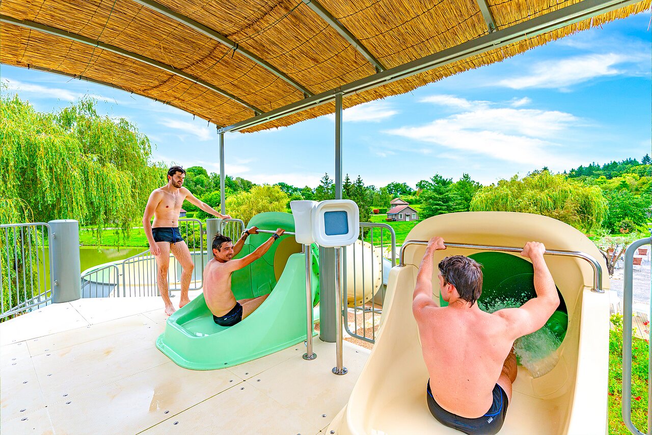 Men enjoying water slides at CAPFUN Grand Cerf campsite in Gimouille (58).