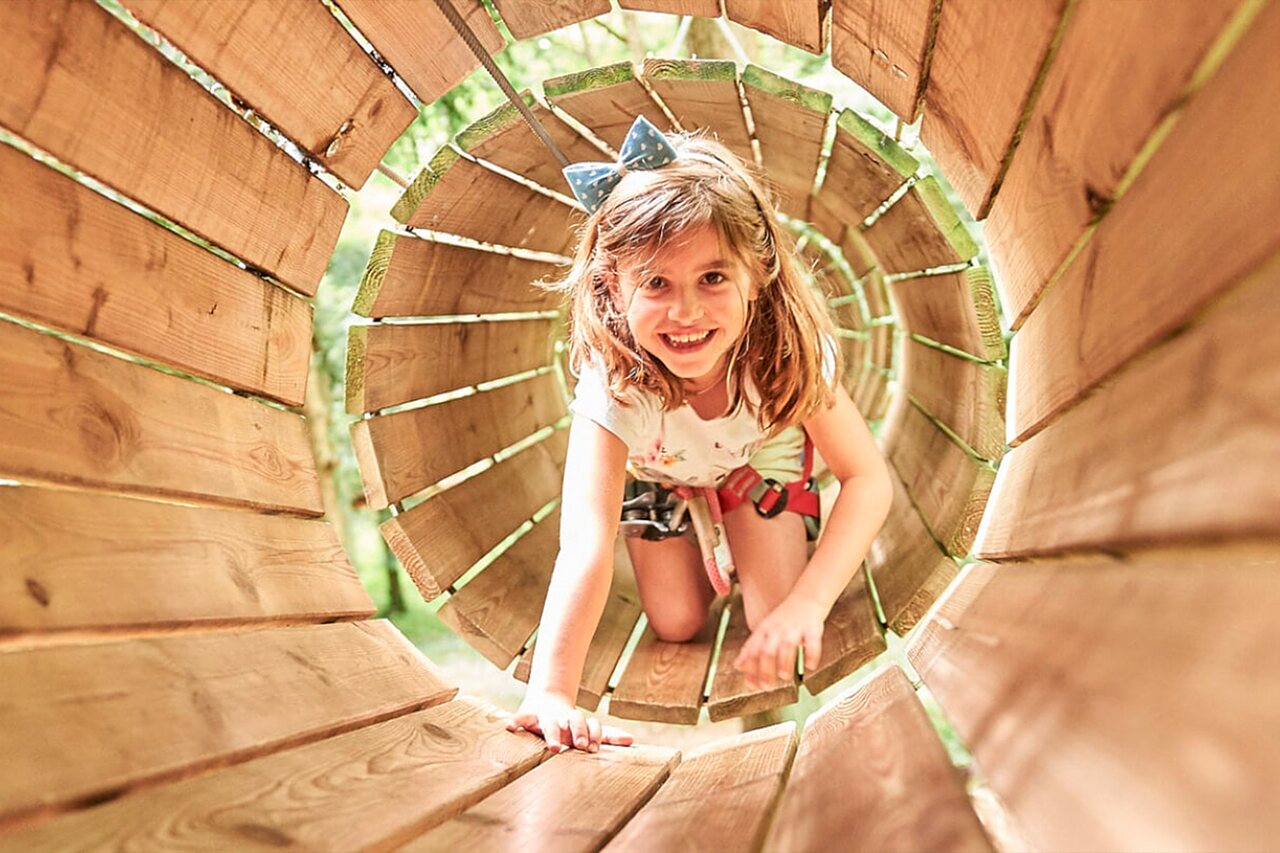 Smiling girl wooden tunnel, CAPFUN Grand Cerf campsite in Gimouille (58).