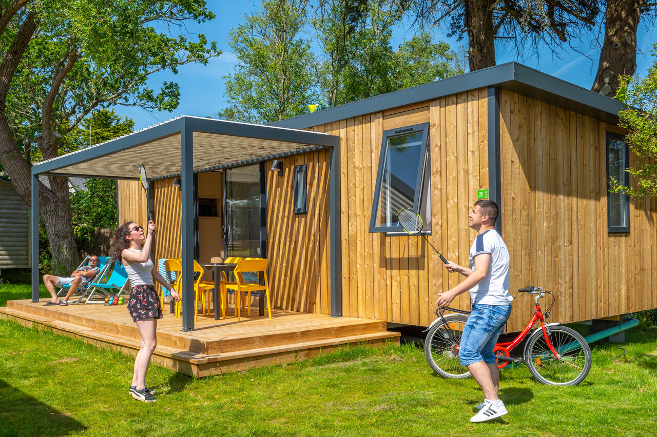 Modern mobile home, couple playing badminton, terrace at CAPFUN Grand Large, FOUESNANT.