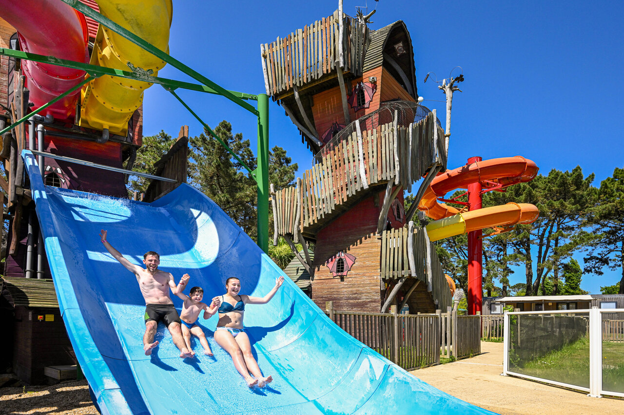 Family sliding down giant water slide at CAPFUN Grand Large campsite in FOUESNANT (29).