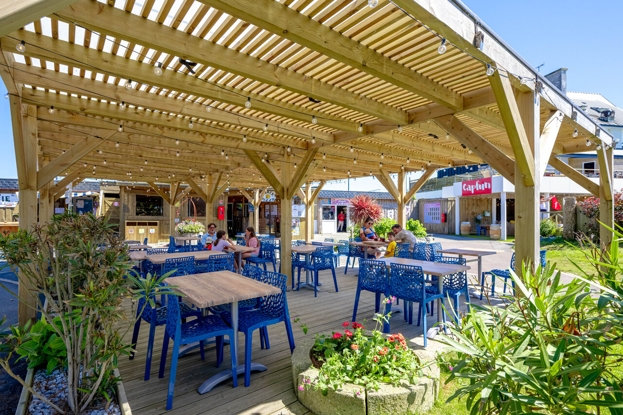 Shaded restaurant terrace, blue tables, CAPFUN Grand Large campsite FOUESNANT (29).