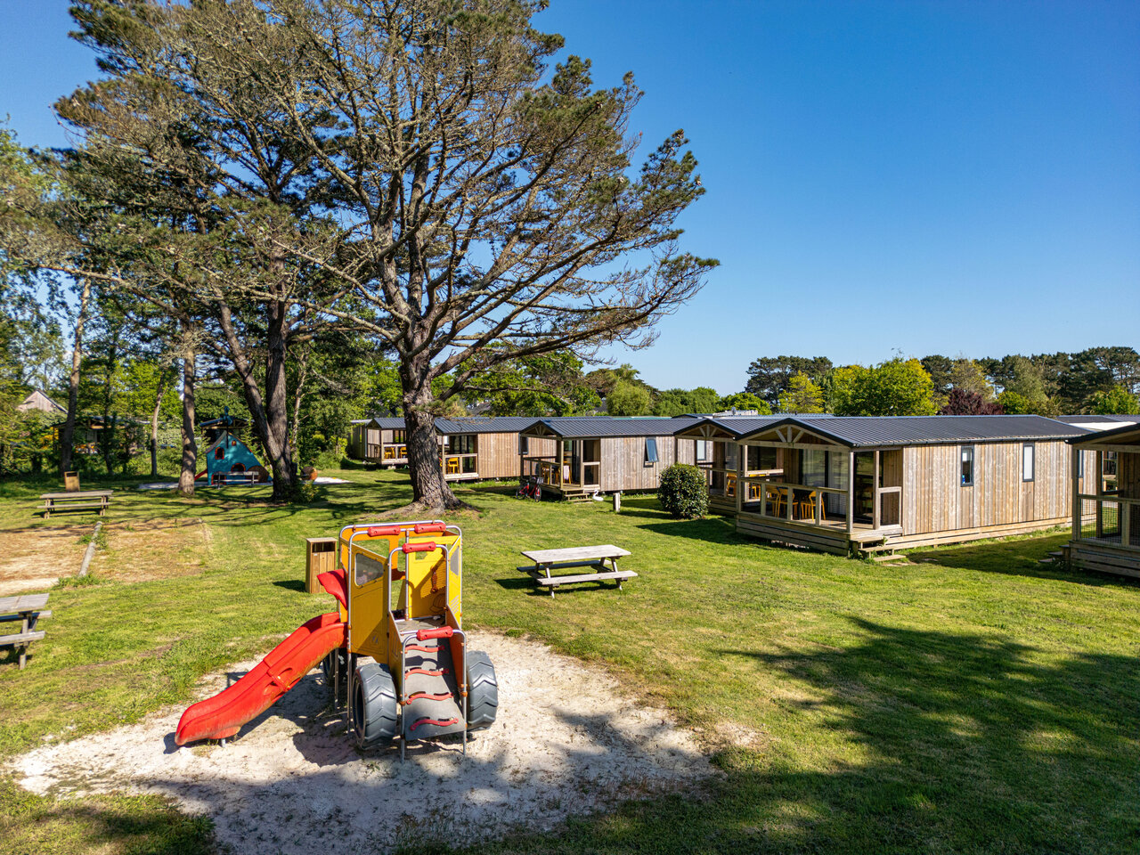 Wooden mobile homes, playground at CAPFUN Grand Large campsite in FOUESNANT (29).