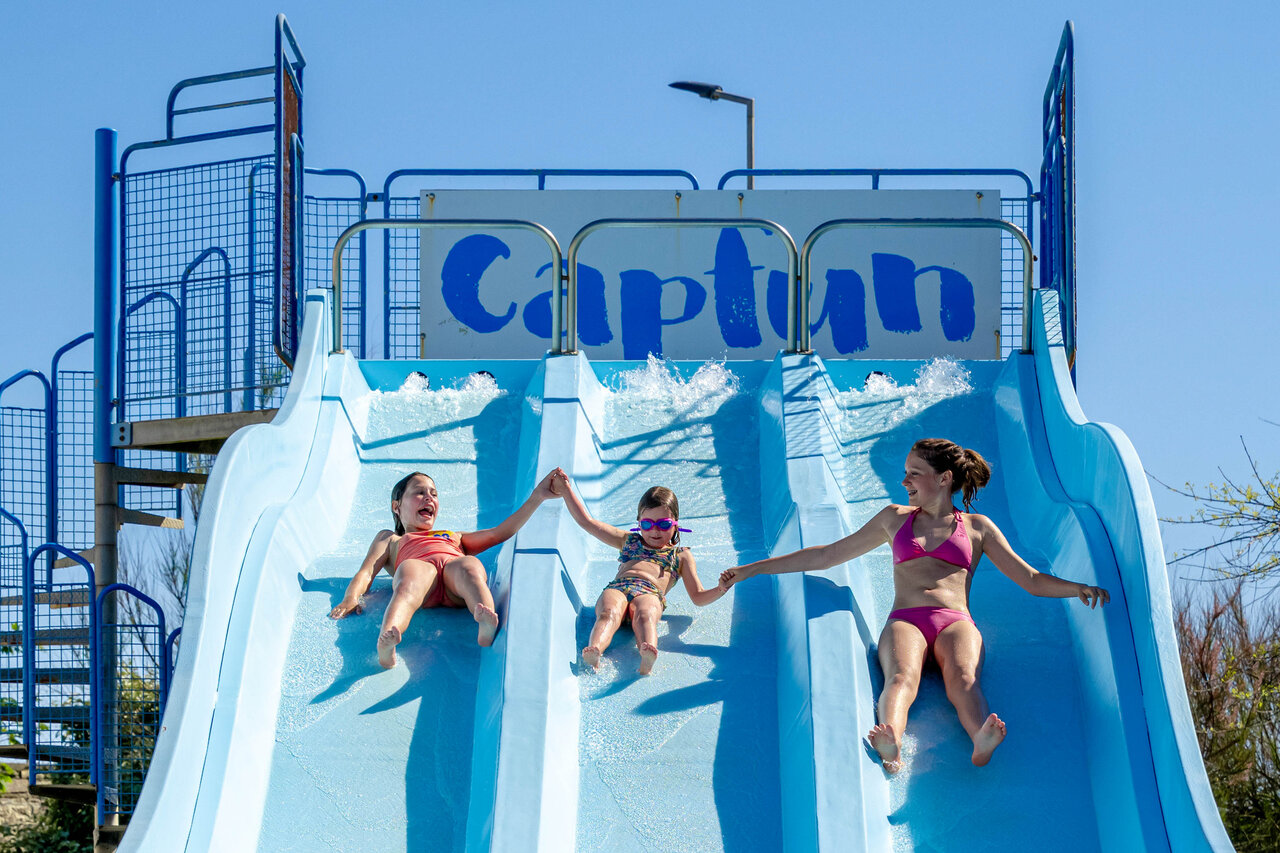 Children on multi-lane water slide at CAPFUN Grand Large campsite in FOUESNANT (29).