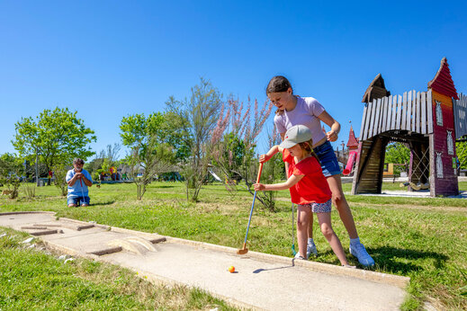 Children playing mini-golf at CAPFUN Grand Large campsite in FOUESNANT (29).