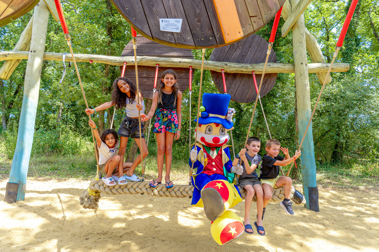 Children and mascot on playground swing at CAPFUN Grand Lierne CHATEAUDOUBLE (26).