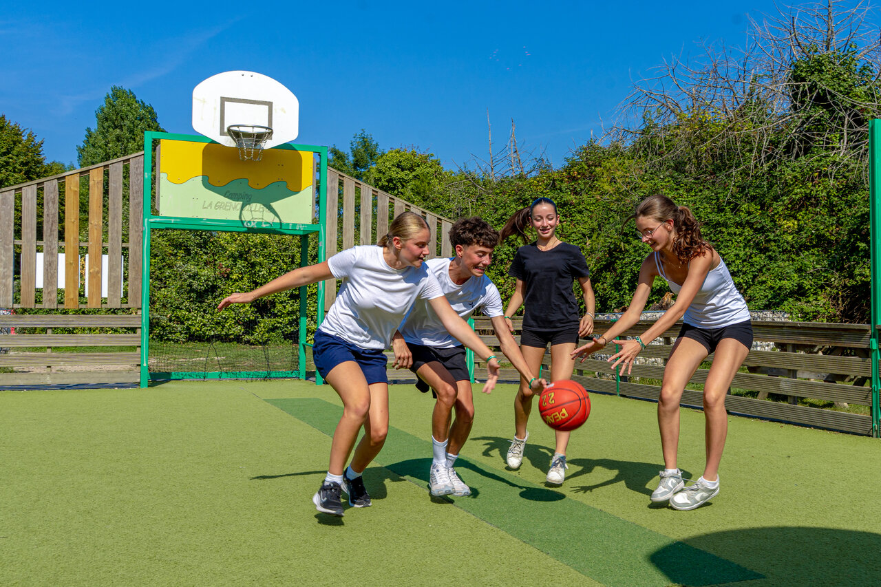 Young people playing basketball on multisport court at CAPFUN Grenouill�re campsite in Su�vres (41).