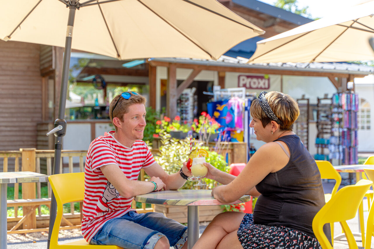 Couple enjoying cocktails on bar-shop terrace, camping CAPFUN Grenouill�re (41).
