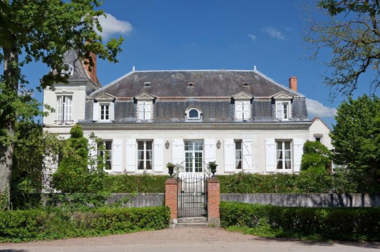 Elegant main building, white facade, mansard roof at CAPFUN Grenouill�re in Su�vres.