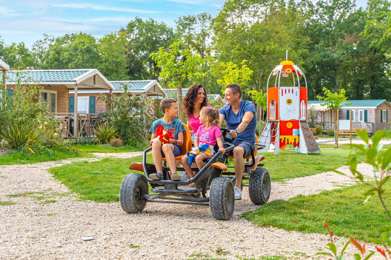 Family on pedal kart, playground at CAPFUN Grenouill�re campsite in Su�vres (41).