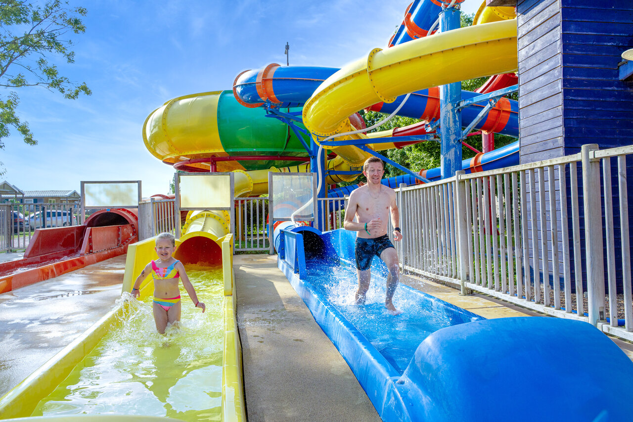 Water slides, man and child having fun at CAPFUN Grenouill�re campsite in Su�vres (41).