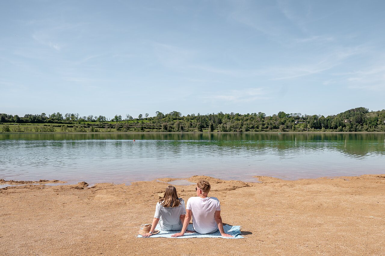 Couple on sandy beach by lake, CLICOCHIC Grisi�re campsite, Clairvaux-les-Lacs.