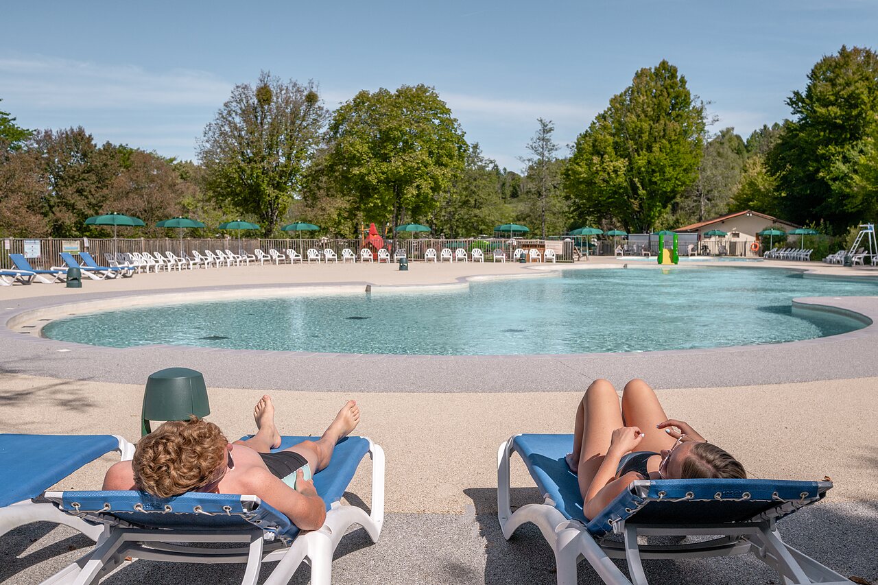 Outdoor swimming pool, slide and sun loungers at CLICOCHIC Grisi�re campsite, Clairvaux-les-Lacs (39).