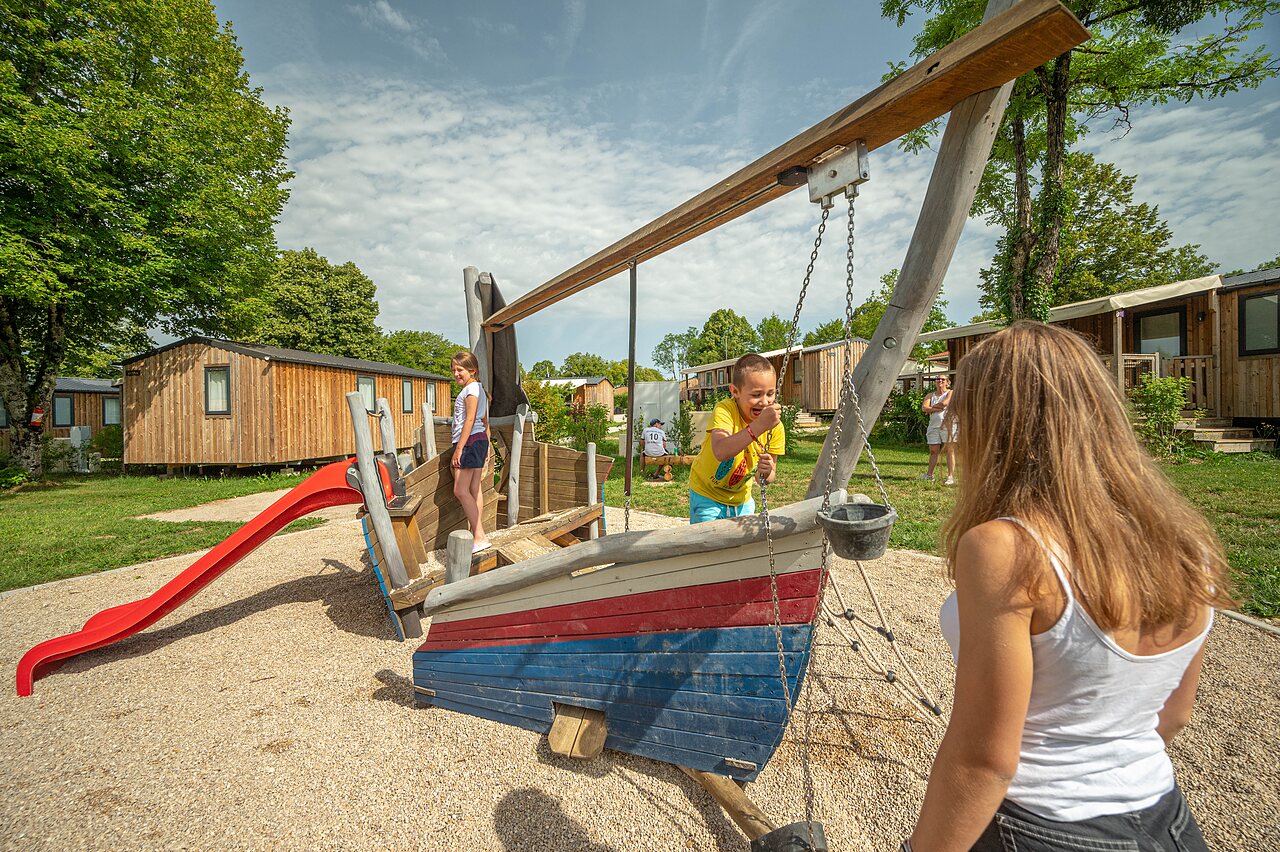 Playground, boat, slide and children at CLICOCHIC Grisi�re campsite (39).