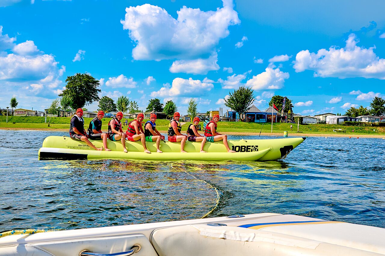 Group on towed banana boat, water activities at CAPFUN Groene Eiland campsite in Appeltern.