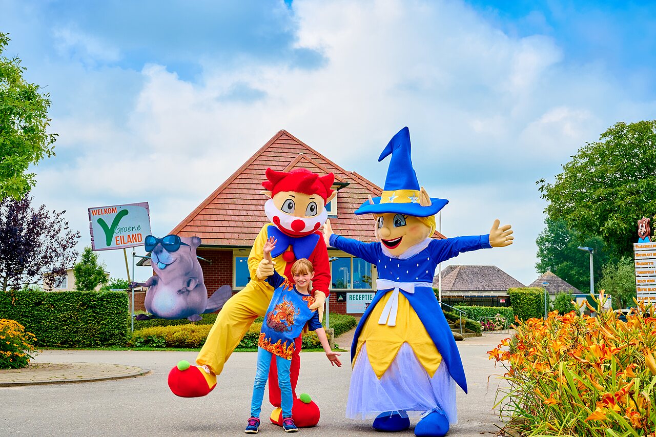 Mascots and smiling child in front of reception at CAPFUN Groene Eiland campsite in Appeltern.