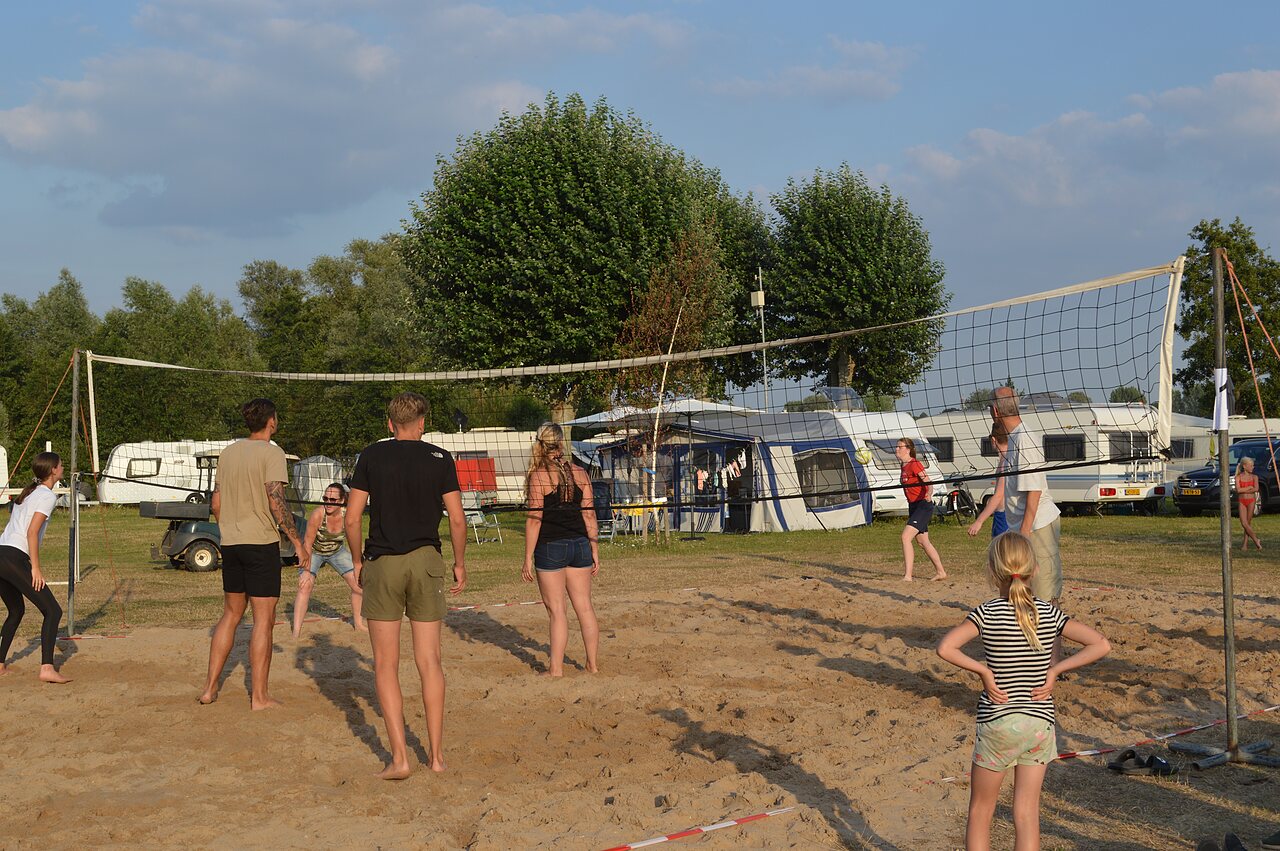 Beach volleyball players on sand court at CAPFUN Groene Eiland campsite in Appeltern.