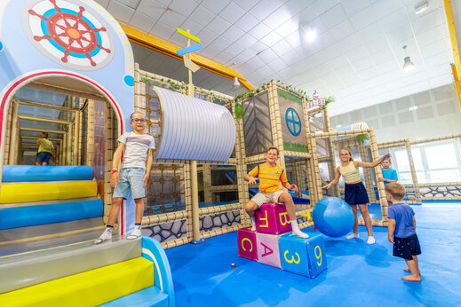 Indoor play area with structures and children at VAGUES OCEANES Grosses Pierres campsite in Saint-Georges-d'Oléron (17).