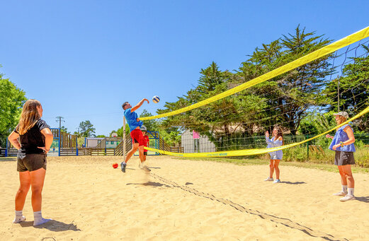 Beach volleyball players on the sports court at VAGUES OCEANES Grosses Pierres campsite in Saint-Georges-d'Oléron (17).
