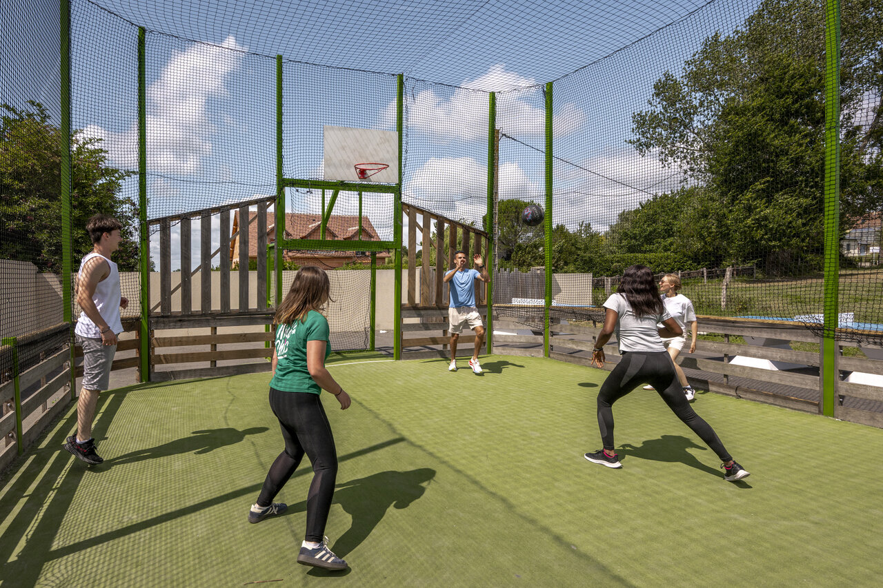 Young people playing basketball on multi-sport court, at campsite CLICOCHIC Haras de Deauville in Touques (14).