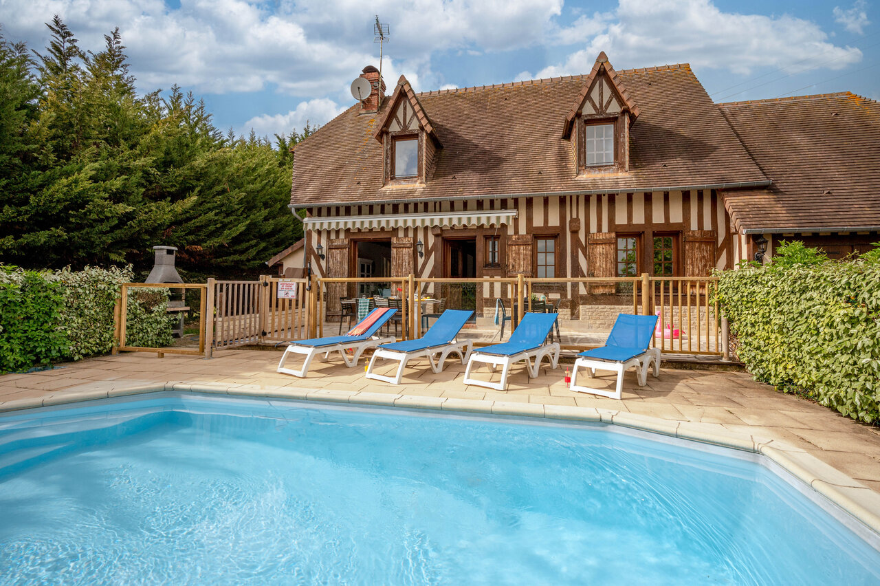 Outdoor pool, sun loungers and Norman accommodation at CLICOCHIC Haras de Deauville (14).