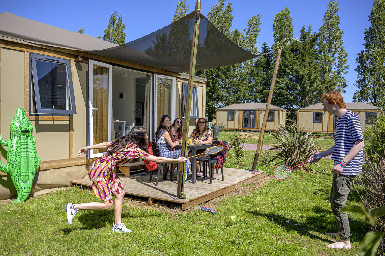 Family playing badminton in front of glamping accommodation, terrace, at CAPFUN Hautes Coutures BENOUVILLE (14).