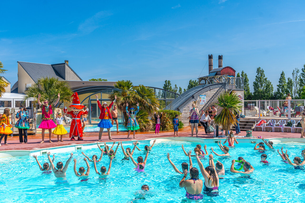 Festive water animation with mascots and campers in the pool at CAPFUN Hautes Coutures campsite in BENOUVILLE (14).