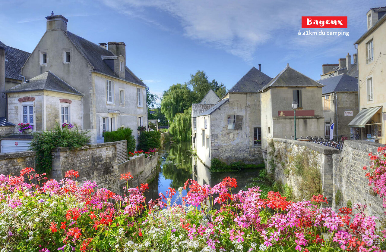 Medieval city of Bayeux, old houses and flowery canal in Normandy.