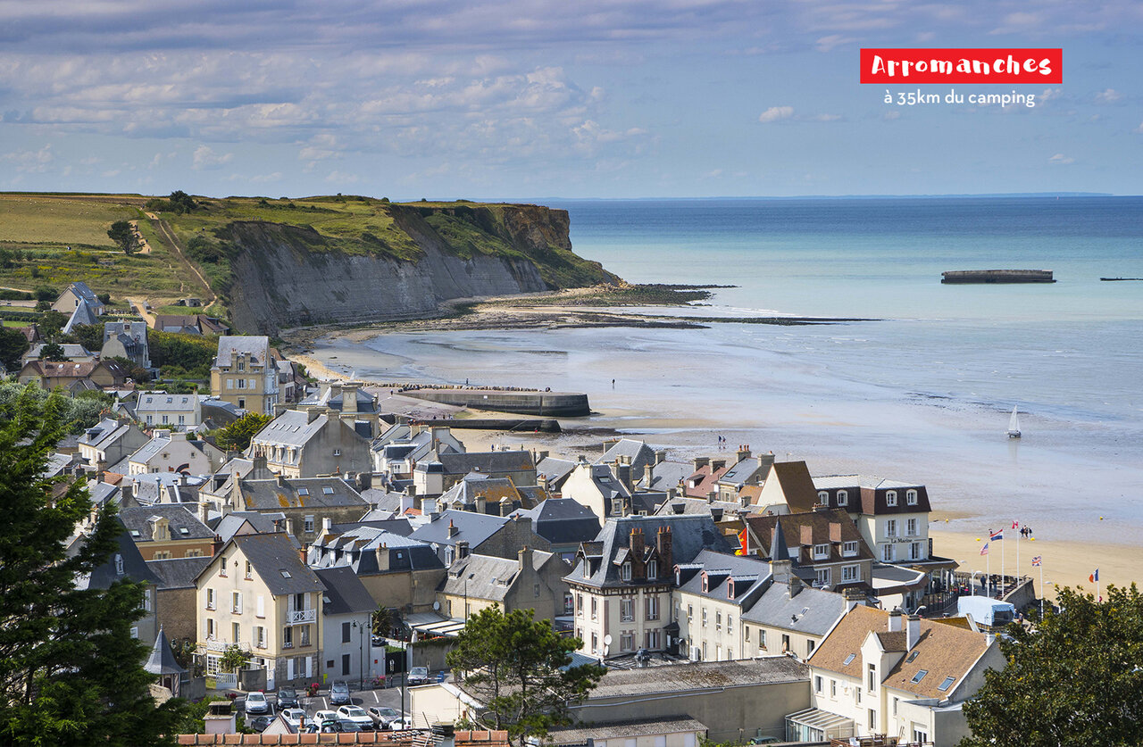 Coastal village of Arromanches-les-Bains in Normandy, beach and remnants of the artificial harbor.