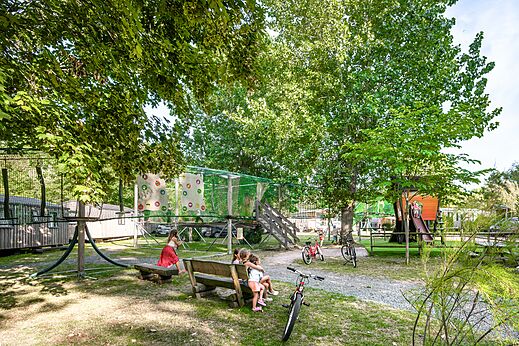 Playground with climbing net, treehouse slide and children at CLICOCHIC Havre de Berni�res campsite in Berni�res-sur-Mer (14).
