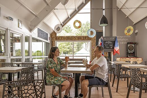 Couple enjoying drinks in the restaurant at camping CLICOCHIC Havre de Berni�res.