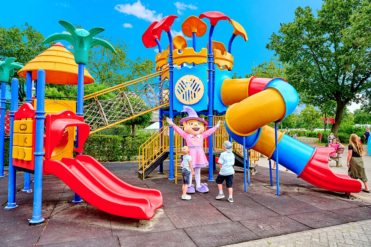 Colorful playground with slides, net, and mascot at CAPFUN Heino campsite in Heino.