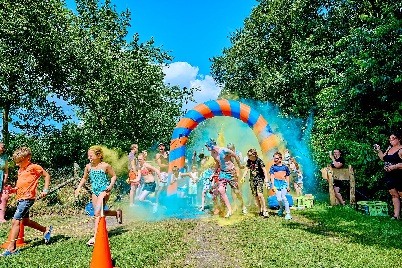 Color run with children and adults under an arch at CAPFUN Heino campsite in Heino.