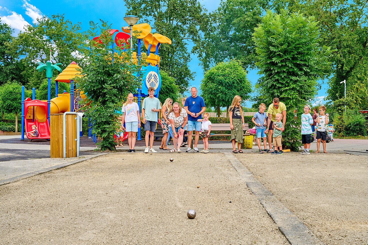 Family playing p�tanque near playground at CAPFUN Heino campsite in Heino.