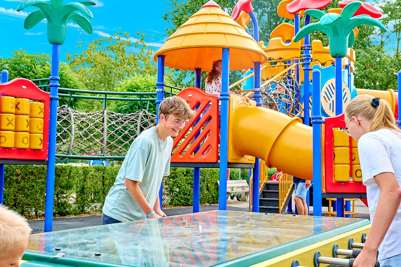Foosball and colorful playground with slides at CAPFUN Heino campsite in Heino.