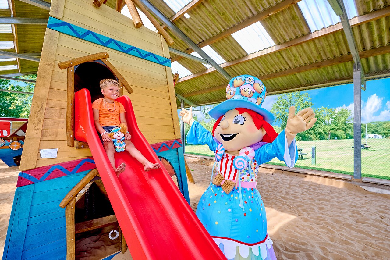 Child on slide and mascot in playground, CAPFUN Heino campsite in Heino.
